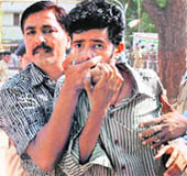 A securityman detains the man who hurled a shoe towards Prime Minister Manmohan Singh during an election rally in Ahmedabad on Sunday.