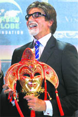 Bollywood actor Amitabh Bachchan laughs as he holds a mask presented to him by a representative from Macau, during a press conference organised by the International Indian Film Academy (IIFA) in Mumbai. The IIFA Awards 2009 will be held in Macau.
