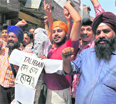 Members of the Youth Akali Dal shout slogans as they hold an effigy of Taliban during a demonstration in Amritsar on Thursday.