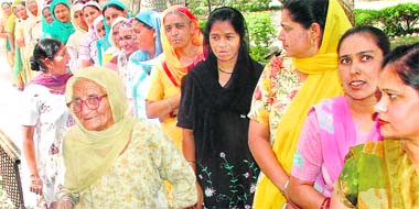 Women stand in a queue to cast their vote outside a polling booth in the Sangrur Lok Sabha constituency