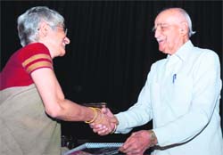 Air Chief Marshal OP Mehra (Retd) presents the award to Neerja Choudhary for reporting on political issues.