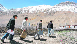EC officials carry EVMs to a polling booth at a tribal village in Kaza, Himachal Pradesh, on the eve of the final phase of LS elections on Tuesday.