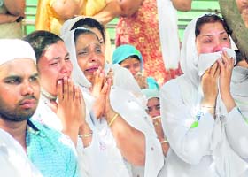 Followers of the Dera Sachkhand give a tearful adieu to Sant Ramanand at Ballan village in Jalandhar