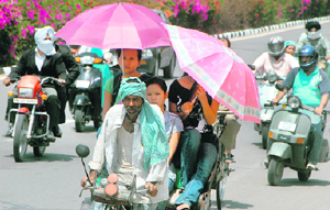 Three girls make a style statement with pink umbrellas on a hot sunny afternoon.