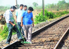 The police looks for landmines on a railway track during a 48-hour bandh called by the Maoists, in Purulia