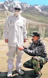 A jawan helps adjust the multi-layered water proof and wind proof snow clothing provided to his colleague in the Drass-Kargil