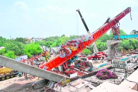 A heavy crane is used to clear wreckage at the site where a pillar supporting a section of the Delhi Metro carriageway collapsed in New Delhi