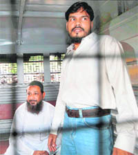 Syed Mohammed Haneef Abdul Rahim (left) and Ashrat Shafiq Mohammed Ansari inside a police van.