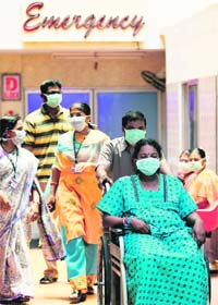Patients, attendants and hospital staff wear protective masks as a part of the precautionary measures after the death of a four-year-old in Chennai