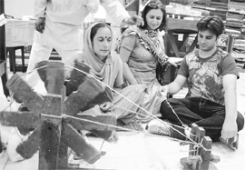 A lady tries her hand at the spinning wheel on Independence Day in Chandigarh.