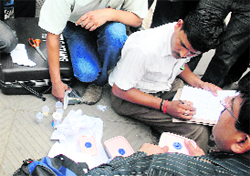 Delhi cops inspect items recovered from the militant.