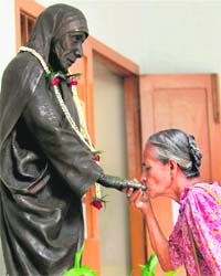 TRIBUTE TO MOTHER: An elderly woman kisses the hand of a statue of Mother Teresa on her 99th birth anniversary at the Missionaries of Charity in Kolkata