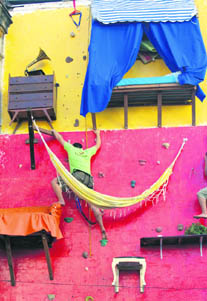 Brazilian artist Tiago Primo scales a wall in Rio de Janeiro