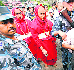 Newly appointed Indian priests Girish Bhatt and Raghavendra Bhatt are escorted by security personnel to take part in a ritual at Pashupatinath temple in Kathmandu.