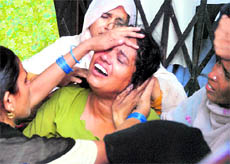 Relatives mourn the death of Afroz at the GTB Hospital in New Delhi on Thursday. Six girls were killed and at least three others injured in a stampede at a secondary school in New Delhi, sparking protests from distraught parents.