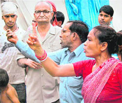 Rimpa Haldar's angered parents argue with the police outside the D-5 Noida residence of businessman Moninder Pandher who was acquitted by the Allahabad High Court in Rimpa Haldar murder case, in Noida on Friday.