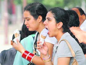 A newly married girl dips into an ice cream on a hot afternoon.