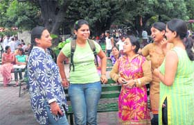 These girls seem to be stealing some carefree, casual, cheerful 'student moments' while on the campus grounds.