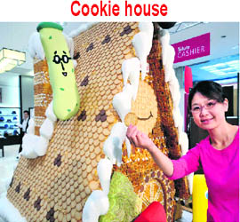 Japanese confectionery artist Chelin displays the 2.1m tall sweet house, decorated with cookies and sugar candies for the sales promotion by Japanese confectioner Tohato at Tokyo’s Matsuzakaya department store