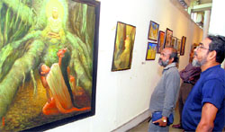 Visitors have a look at the contemporary paintings by a Kolkata-based group Pentagon, at the Museum and Art Gallery in Chandigarh.