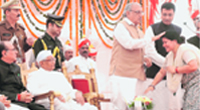 Chief Minister Bhupinder Singh Hooda blesses Geeta Bhukkal, MLA from Jhajjar. Randeep Singh Surjewala, Haryana Governor Jagan Nath Pahadia and Ajay Singh Yadav look on during the oath-taking ceremony at Haryana Bhavan in Chandigarh