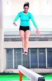 A gymnast shows her skills on a balancing bar on the second day of the Women Sports Festival in Ludhiana.