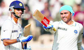 Batman Returns: Virender Sehwag raises his bat on completing his double century as Rahul Dravid cheers on, in Mumbai on Thursday. Sehwag was unbeaten on 284 at the end of Day 2.