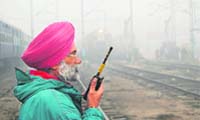 A Railways official monitors the passage of trains on a foggy day at Amritsar railway station 