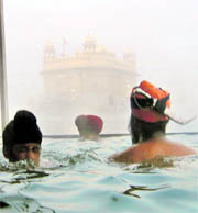 Braving intense cold, devotees take a dip in the Golden Temple sarovar on the birth anniversary of Guru Gobind Singh in Amritsar on Tuesday.