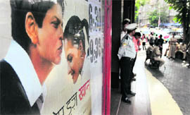 A private security guard and policemen stand guard outside a movie theatre set to show actor Shah Rukh Khans new film My Name Is Khan in Mumbai on Wednesday.