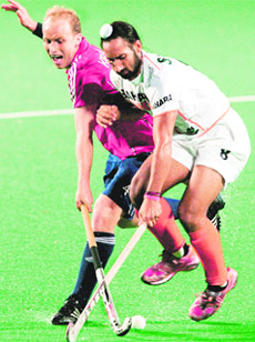 Indias Sardar Singh and Englands Glenn Kirkham vie for the ball at World Cup tournament in New Delhi on Saturday. India lost the match 2-3. 