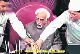 A TV grab shows MPs trying to snatch copies of the Bill from RS chairman Hamid Ansari