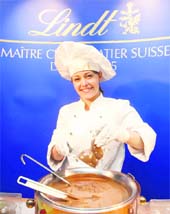 A Maitre Chocolatier of Swiss chocolatier Lindt & Spruengli holds a cast of chocolate bunny over a pot of liquid chocolate.