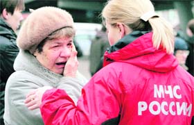 A woman cries while standing next to an Emergencies Ministry member near Park Kultury metro station in Moscow