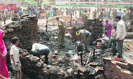 Labourers and firemen at work after the fire destroyed six shanties at Colony No. 5 in Chandigarh on Friday.