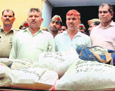 The UP Police parades CRPF personnel Vinod Paswan and Vinesh along with retired Sub-Inspector Nandan and displays the bags containing three-and-a-half quintals of live cartridges recovered from them at Rampur on Friday. 