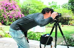 Karam Sodhi examines the frame of his picture through the viewfinder of a Mamiya medium format camera. Photo: Avi Sodhi