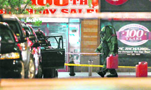 A member of the New York police bomb unit carries a gas can from a suspicious vehicle in New York on Thursday.