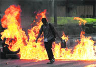 A Red Shirt protester burns tyres on a deserted road during a rally in Bangkok