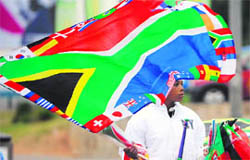 A street vendor selling flags, waves a South African national flag decorated with flags of the countries participating in the 2010 World Cup, in the streets of Johannesburg, on the eve of the biggest football tournament, on Thursday.