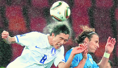 South Koreas midfielder Kim Jung-Woo (L) heads the ball ahead of Uruguays striker Diego Forlan during their pre-quarterfinal tie in Port Elizabeth. Uruguay won the match 2-1 to reach the World Cup quarterfinals for the first time in 40 years.