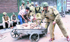Policemen remove bricks and stones from a road a day after violent clashes with protesters in Srinagar on Tuesday.