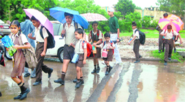 Schoolchildren on their way to school in rain