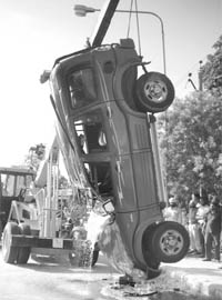 A crane lifts a Scorpio that turned turtle near the Mandi Board office in Mohali.