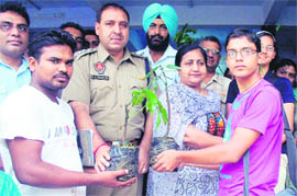 ACP Raj Kumar and principal of SCD Government School distribute saplings among students in Ludhiana on Wednesday.