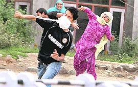 Protesters hurl stones at the police in Srinagar on Friday.