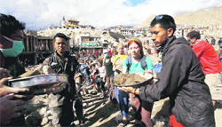Army men and foreign tourists undertake rescue work in Leh