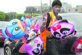 A young boy sells inflatable toys on the city street