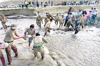 Border Road Organisation personnel and local volunteers try to stop the overflowing water at Taru Thang near Leh