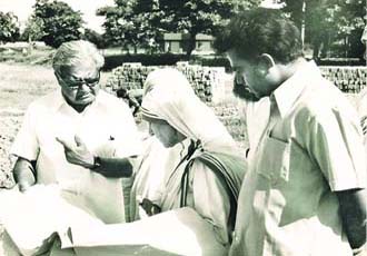 The Mother discusses drawings of the home at the site